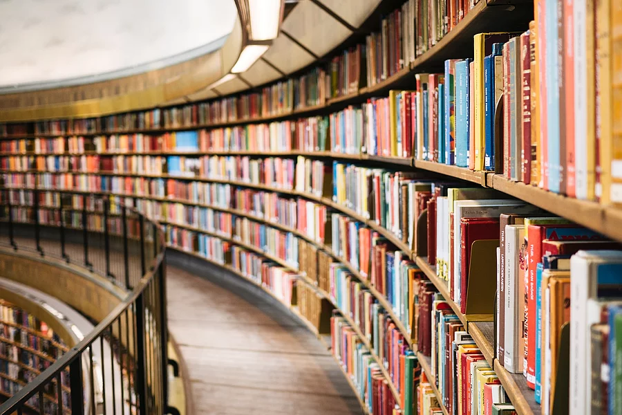 Cărți așezate pe un raft de lemn maro într-o bibliotecă din Stockholm.